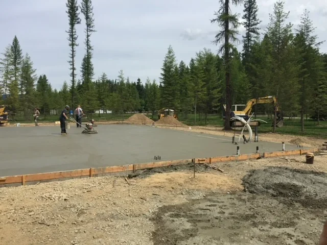 Construction crew and heavy equipment on an active job site, showcasing excavation machinery and site preparation work.