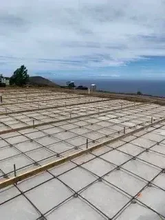 Graded concrete pad with compacted base and grid layout for foundation work
