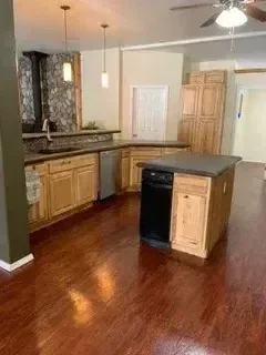 Kitchen with wood cabinets, granite countertops, and new flooring installation